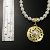 Gold silver round pendant with a pearl necklace