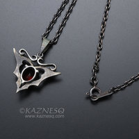 Goth taste silver pendant necklace with oval garnet and gold leaf