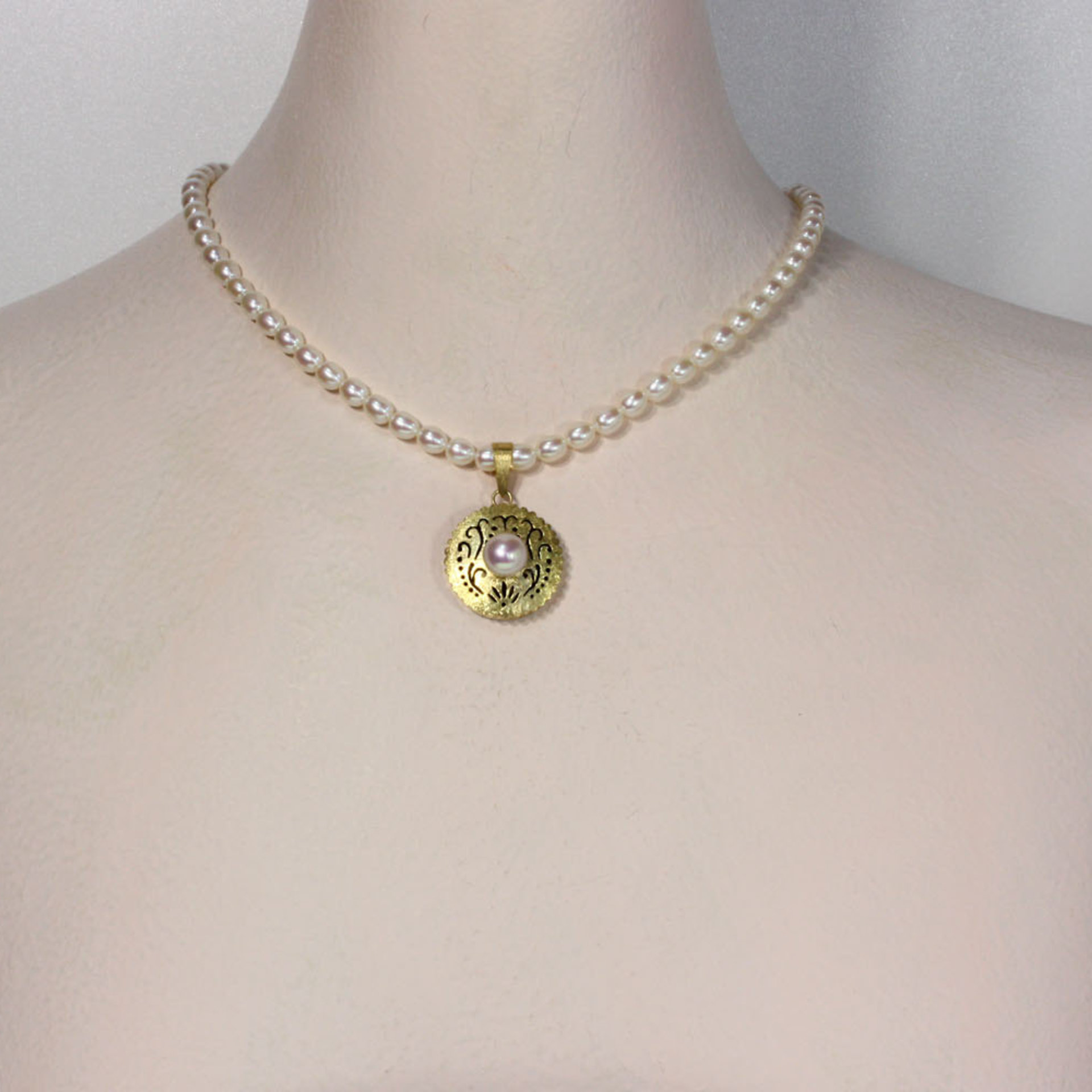 Gold silver round pendant with a pearl necklace