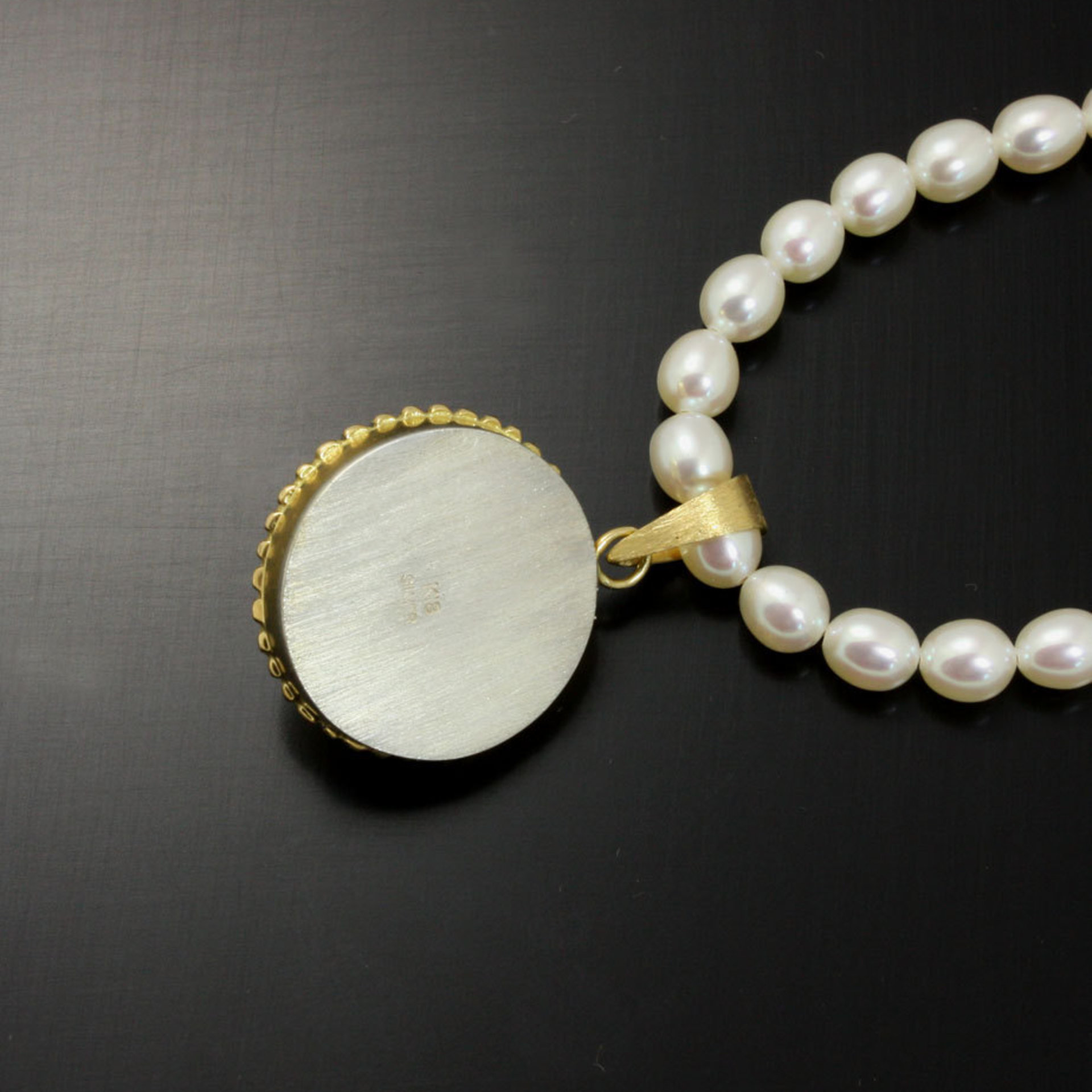 Gold silver round pendant with a pearl necklace