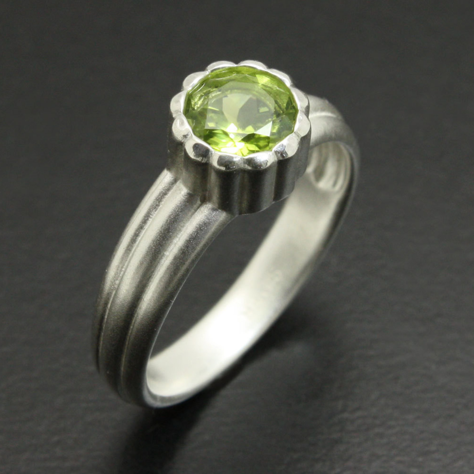 SOLD: Semicylindrical pattern sterling ring with a round peridot