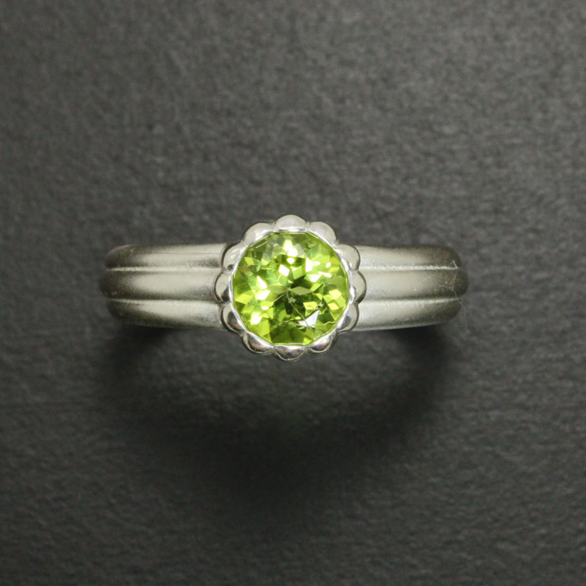 SOLD: Semicylindrical pattern sterling ring with a round peridot