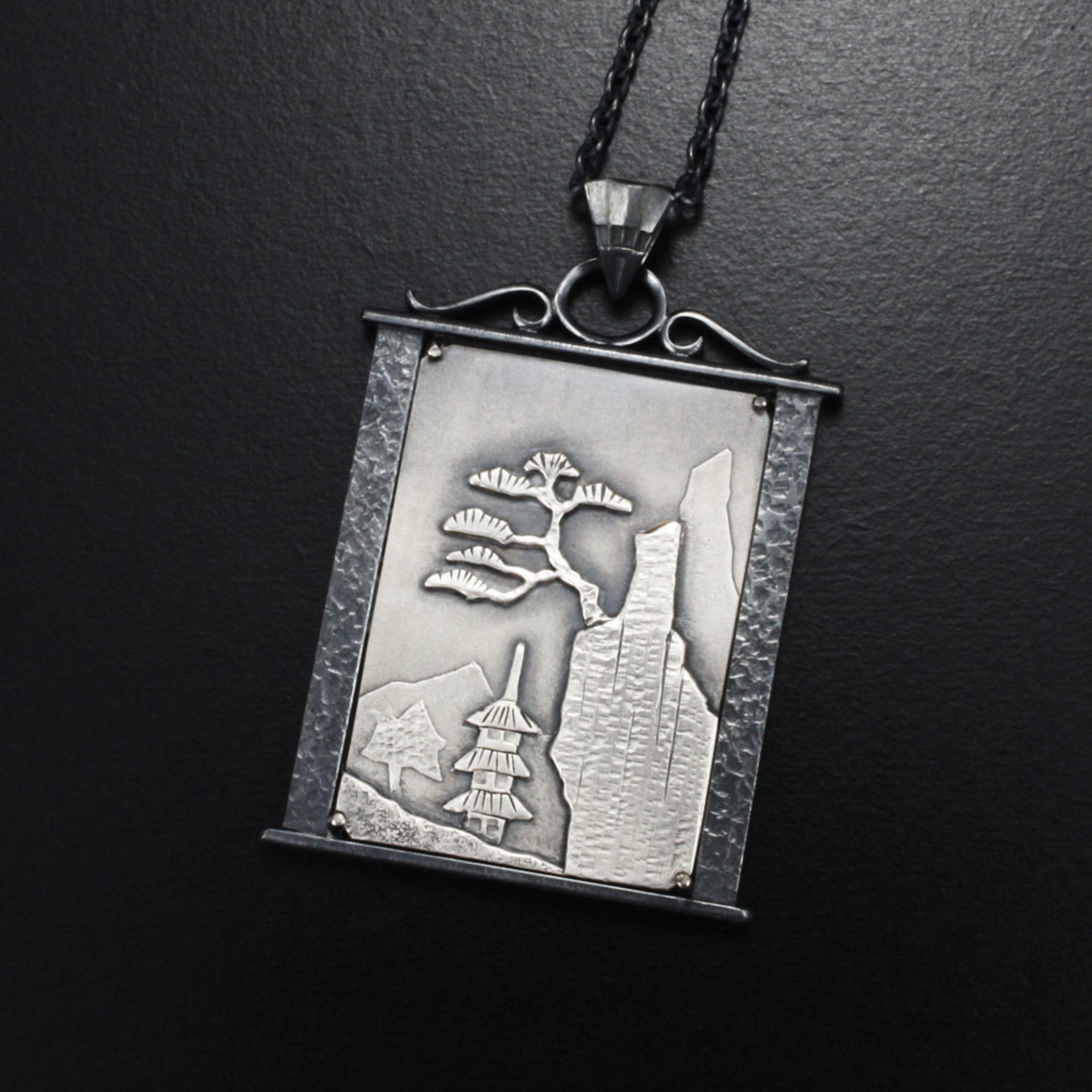 Pine tree on a cliff silver pendant