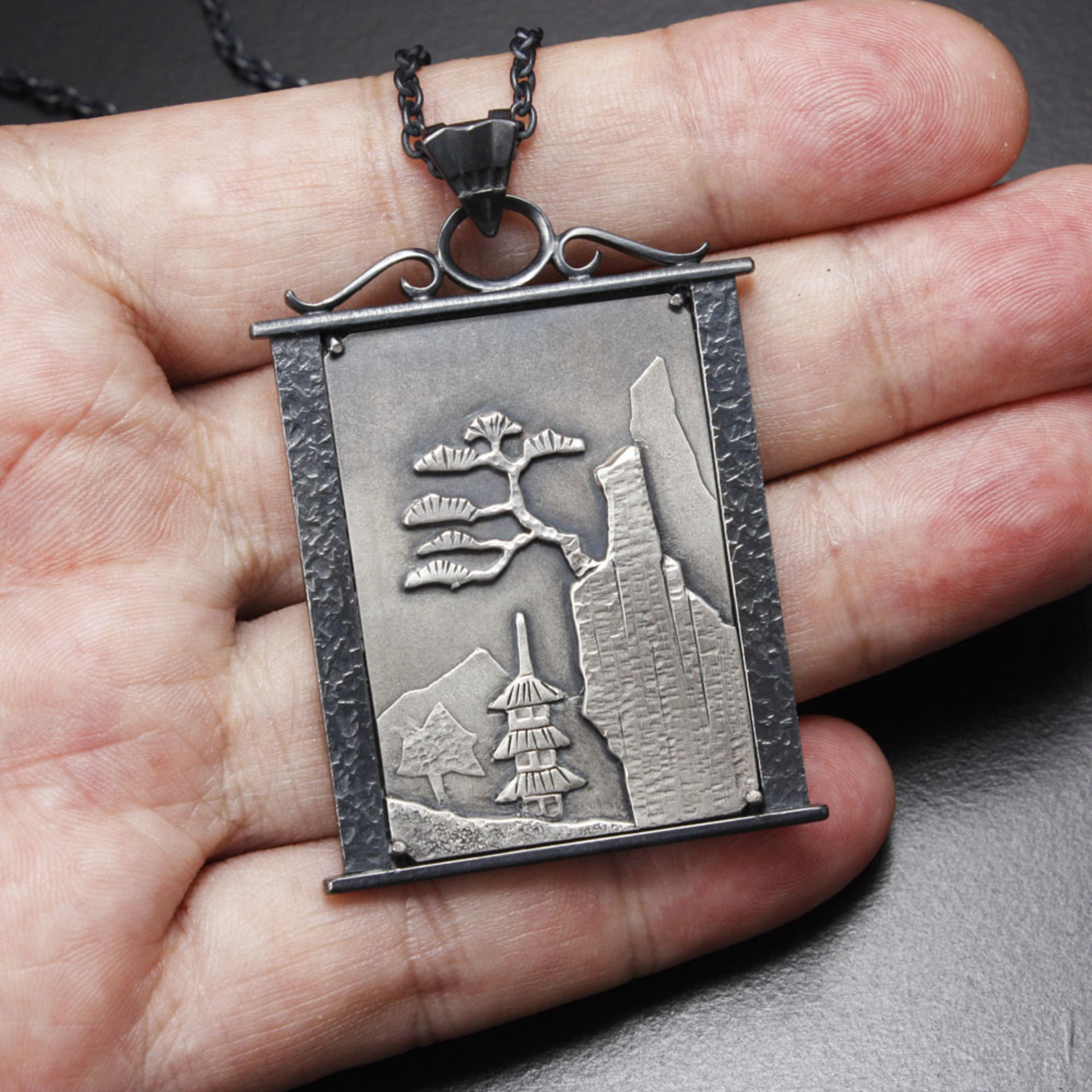 Pine tree on a cliff silver pendant