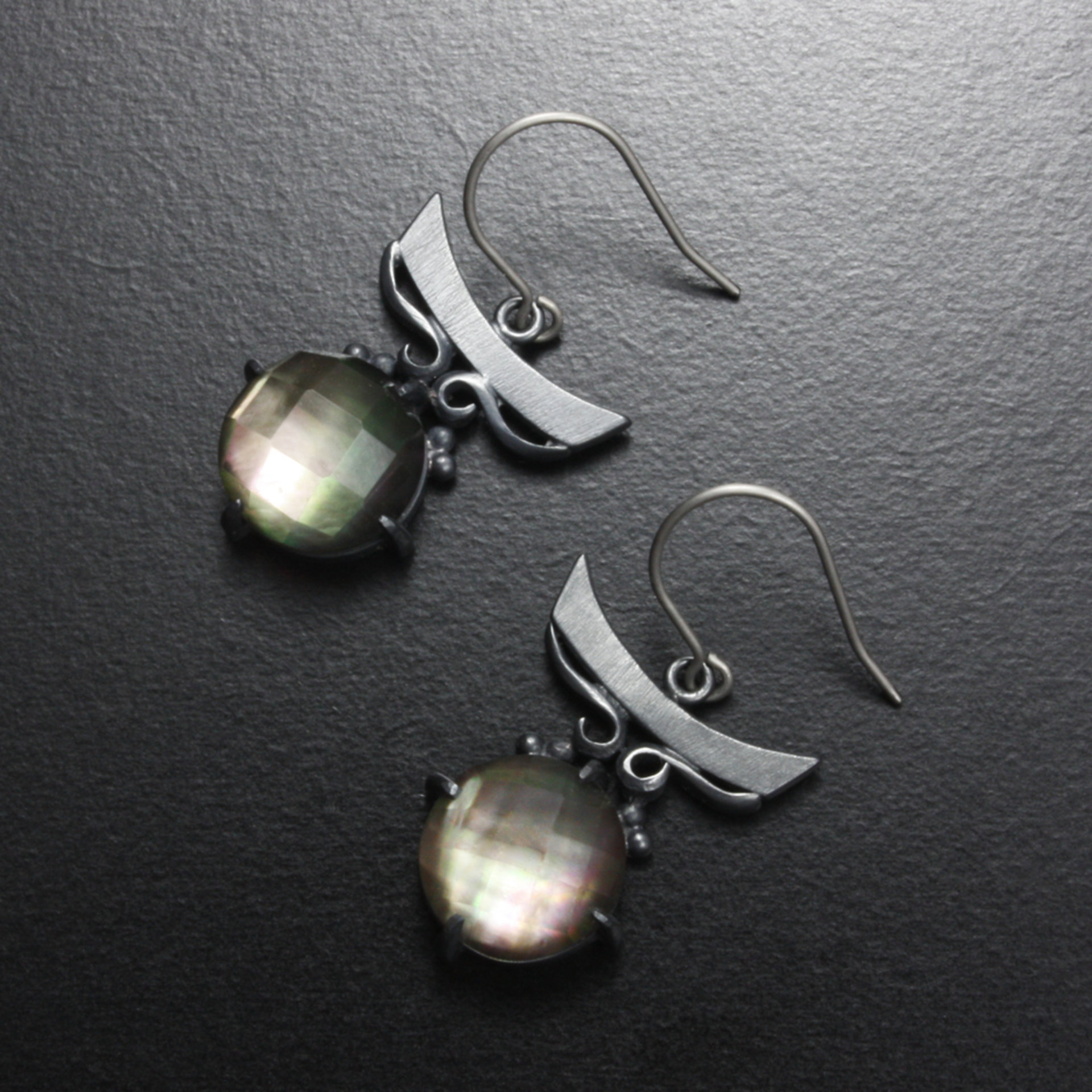 Silver earrings of quartz backed up by black pearl oyster