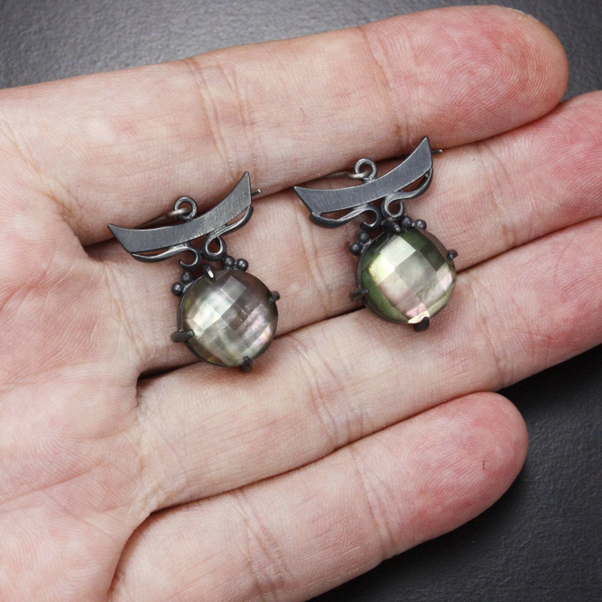 Silver earrings of quartz backed up by black pearl oyster