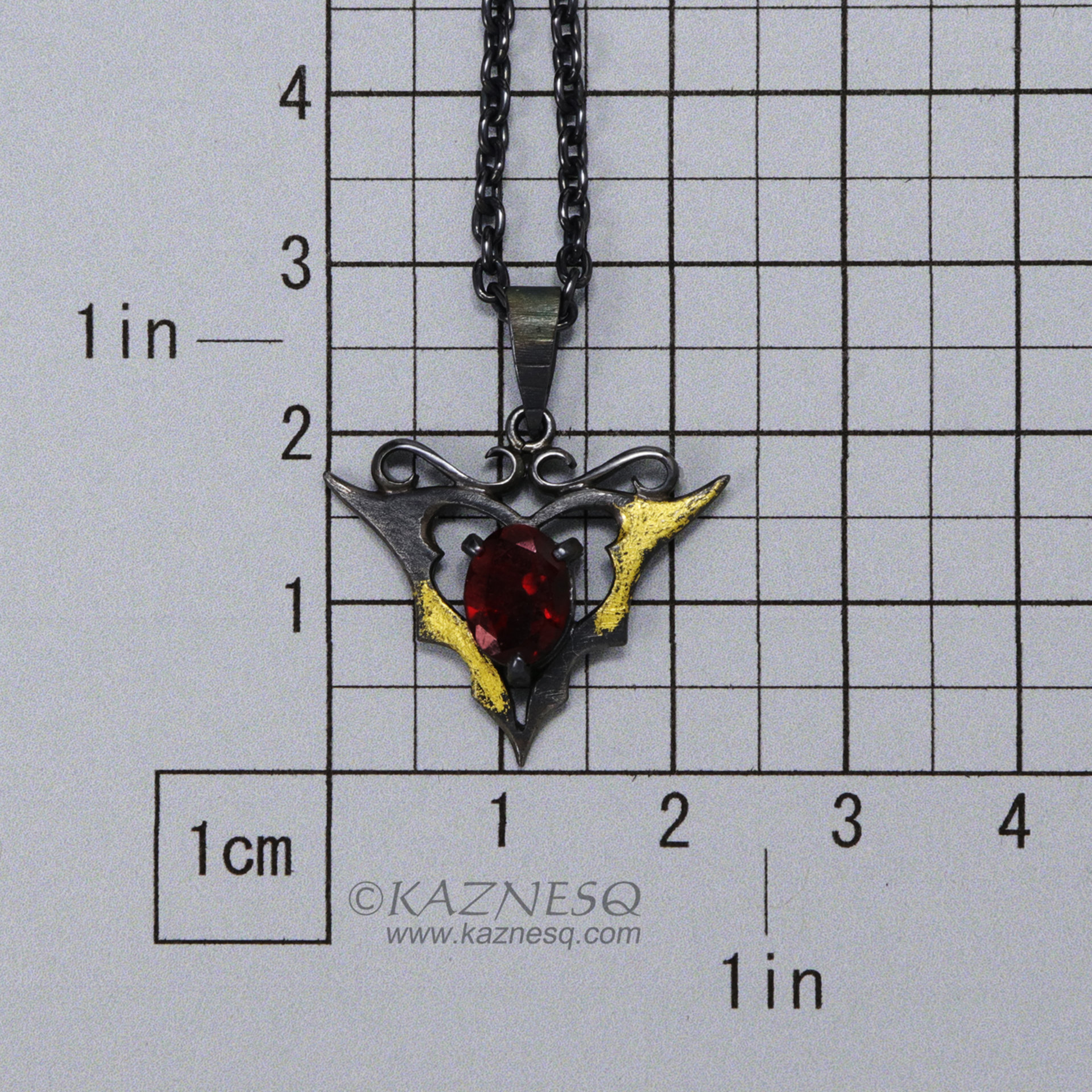 Goth taste silver pendant necklace with oval garnet and gold leaf