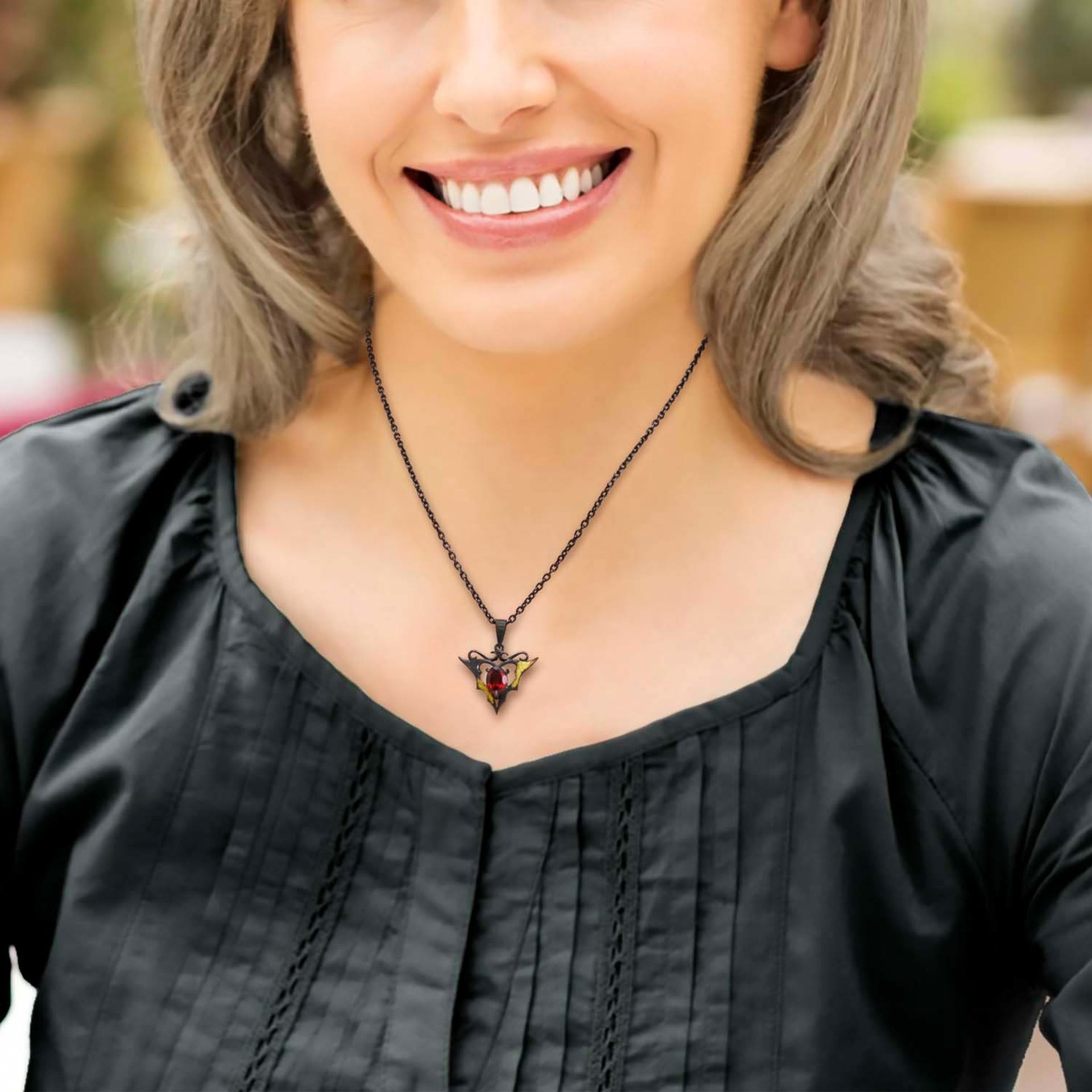 Goth taste silver pendant necklace with oval garnet and gold leaf