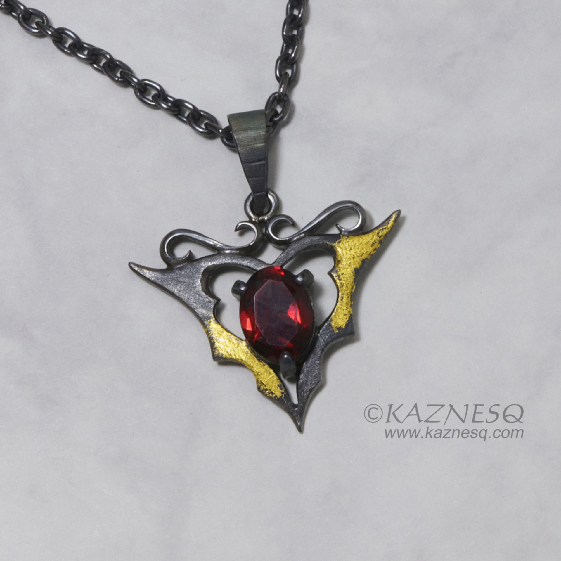 Goth taste silver pendant necklace with oval garnet and gold leaf