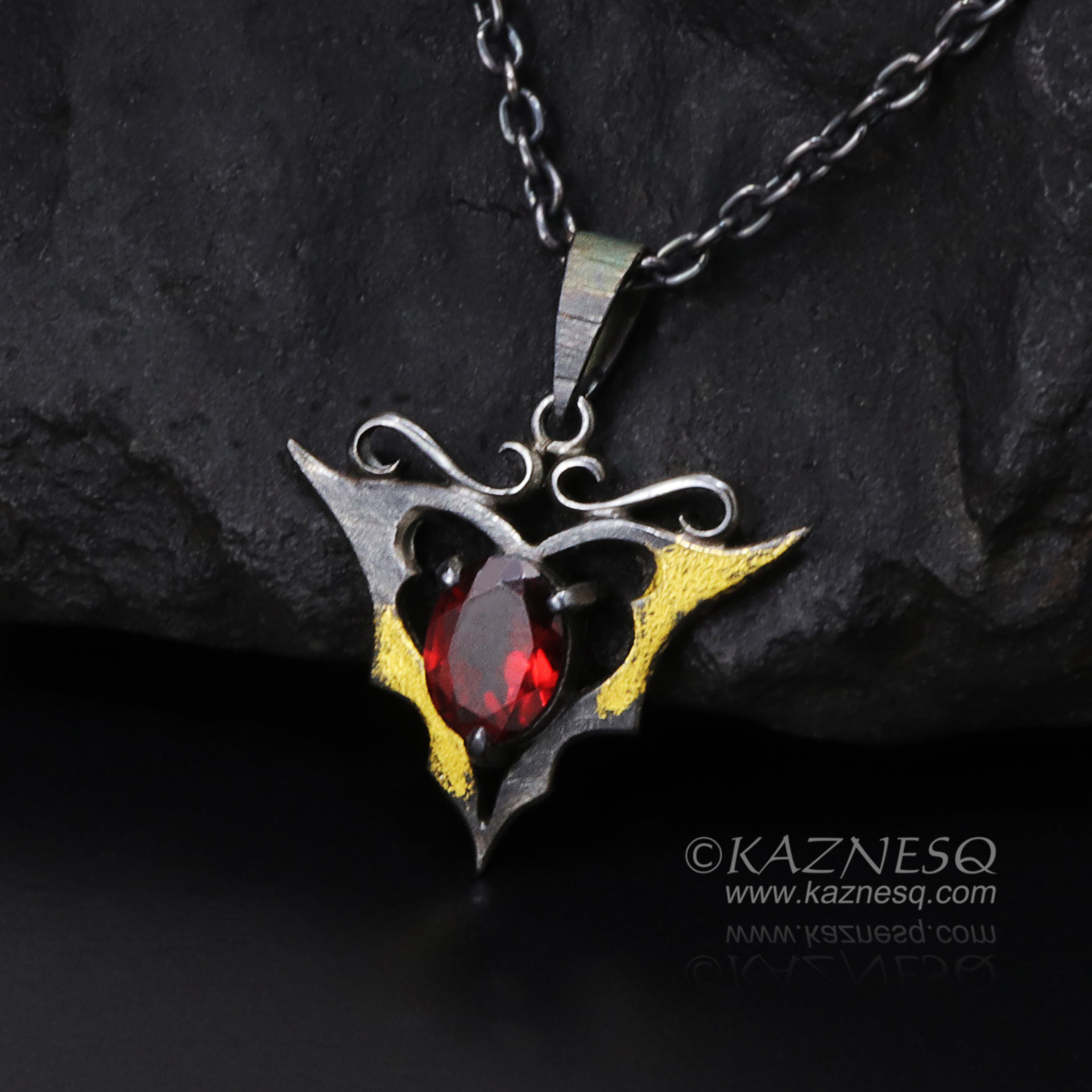 Goth taste silver pendant necklace with oval garnet and gold leaf