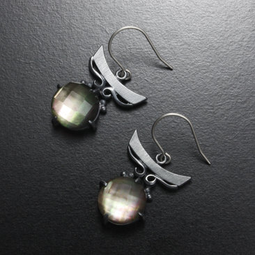 Silver earrings of quartz backed up by black pearl oyster